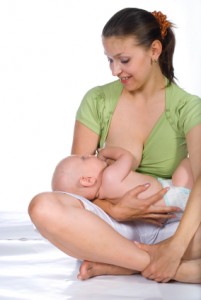 The sitting woman is breast-feeding her baby